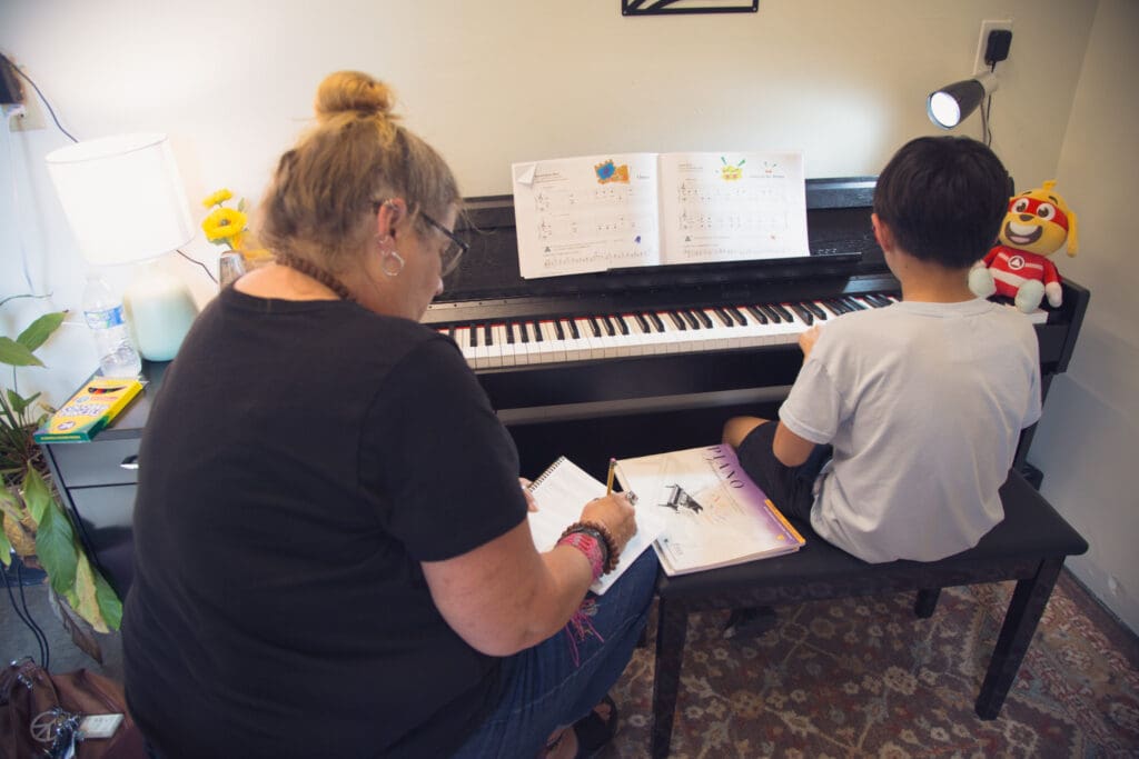 Piano teacher working with a student during a private lesson