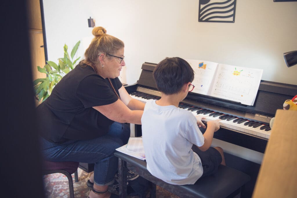 Piano teacher working with a student during a private lesson